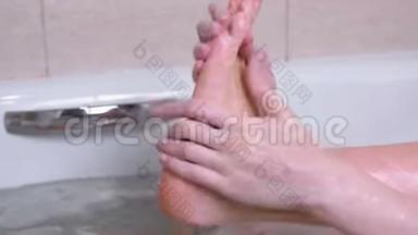 女人正在浴室里用手洗脚。 把擦洗脚，脚特写。